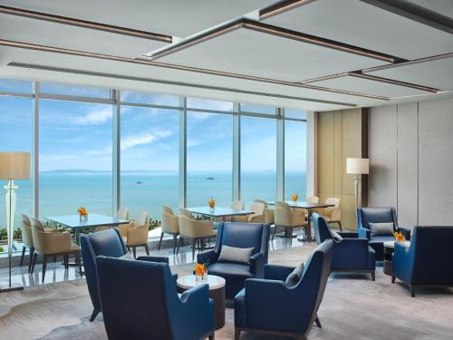厦门厦门海景洲际酒店的餐厅设有蓝色的椅子和桌子以及窗户。