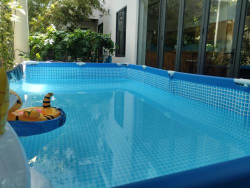 岘港La Maison De Fleurs的蓝色瓷砖游泳池,船上有玩具