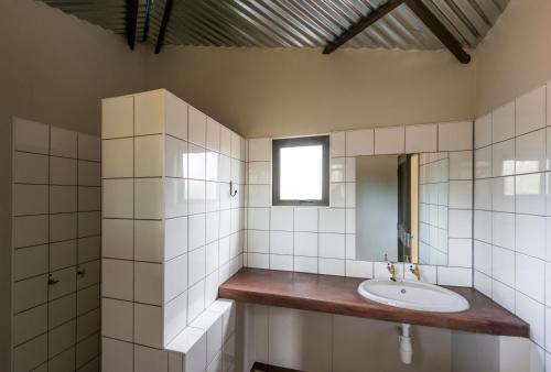纳穆托尼Onguma Tamboti Campsite的一间带水槽和镜子的浴室