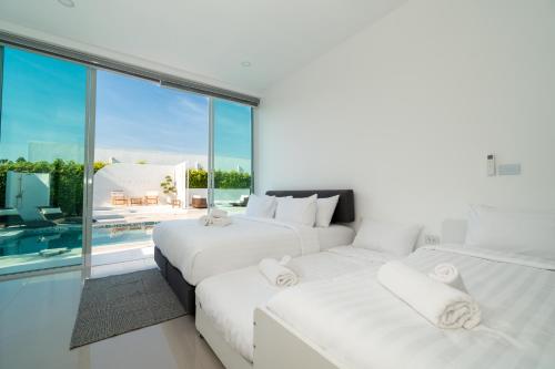 考陶The Stay Huahin - Luxury Private Pool Villa的带大窗户的客房内的2张白色床