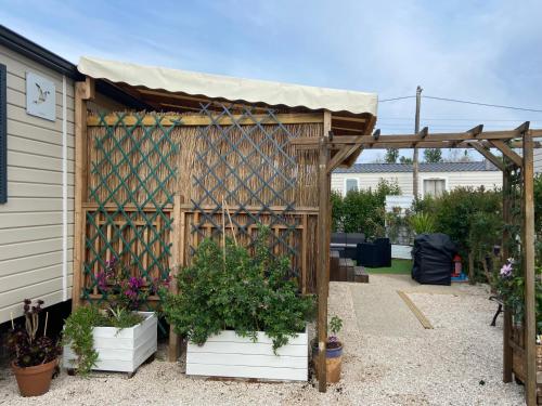 弗雷瑞斯Vos meilleures vacances au Montourey!的一座种植了木凉棚和盆栽植物的花园