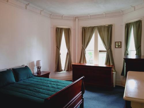 普兰菲尔德Mini Mansion Hotel affordable stays Plainfield NJ near public transportation的一间卧室设有绿色的床和窗户。