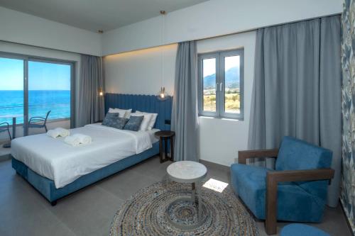 莫什劳斯Mochlos Blue的配有一张床和一把椅子的酒店客房
