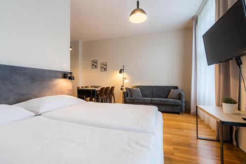 布拉格EA ApartHotel Melantrich的卧室配有一张白色的大床和一张沙发。