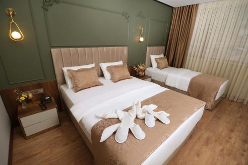 特拉布宗Bayrak Grand Hotel的两张位于酒店客房的床,上面有两双鞋