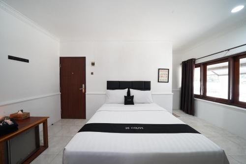 三宝垄DS Colive Marina的卧室设有一张白色大床和一扇窗户。