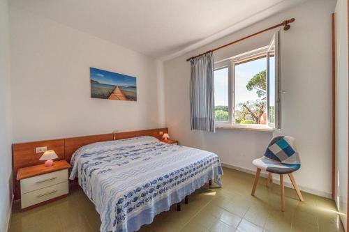 普罗基奥Villa Cecilia - Appartamenti的卧室配有床、椅子和窗户。