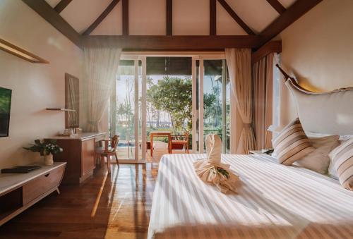 库德岛库德岛天堂海滩度假村的一间卧室设有一张大床和大窗户