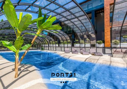 库瑞尼卡慕斯卡Port 21 Pura Pool & Design Hotel - Adults Only的一座带游泳池的建筑前的棕榈树
