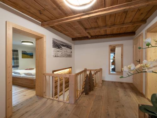 蒂罗尔-基希贝格Appartement Am Hof Untertann的走廊设有木制天花板和一张位于客房内的床