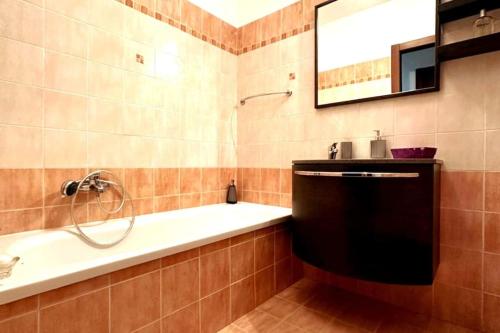 塞尔莫内塔Appartamento Oasi di Pontenuovo的带浴缸、水槽和镜子的浴室