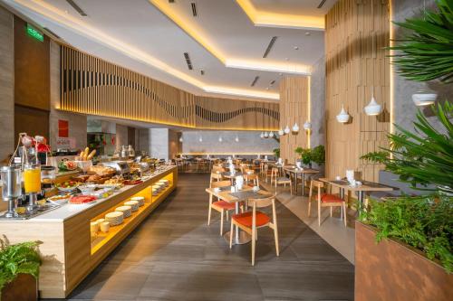 岘港Estrella Boutique Hotel的一间带桌椅的餐厅以及一间自助餐