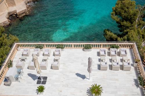 伊利塔斯Hotel ROC Illetas & SPA的享有带椅子的游泳池和海洋的空中景致