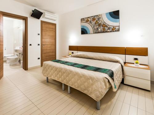 比比翁Ca' del Faro Bibione的一间带大床的卧室和一间浴室