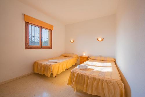 卡尔佩Villa Fabiola - PlusHolidays的客房设有两张床和窗户。
