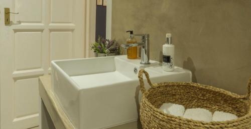 侯斯普瑞特Kingfisher Creek Cottage的一间带白色水槽和篮子的浴室