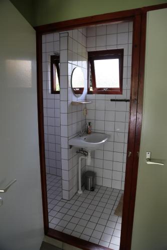 't HorntjeHuisje Vogelsand的白色瓷砖浴室设有水槽和镜子