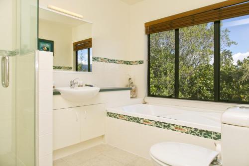 图朗伊汤加里罗旅馆的带浴缸、水槽和窗户的浴室