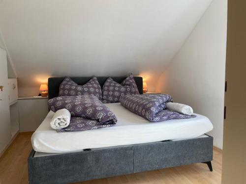 塞博登Maxi'Seeblick Apartments的一张床上的紫色枕头