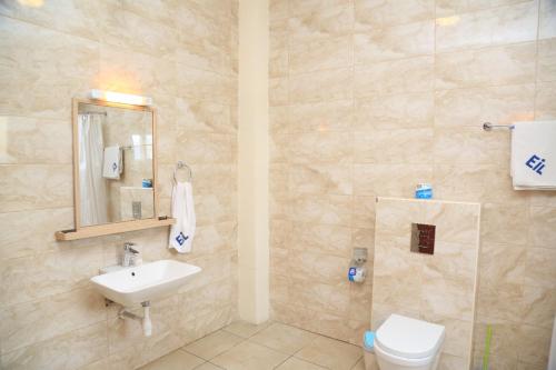 基加利Executive Suites的一间带水槽、卫生间和镜子的浴室
