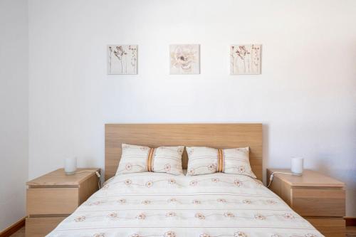 塞辛布拉Casa Alto da Serra Sesimbra的卧室配有一张墙上三幅照片的床