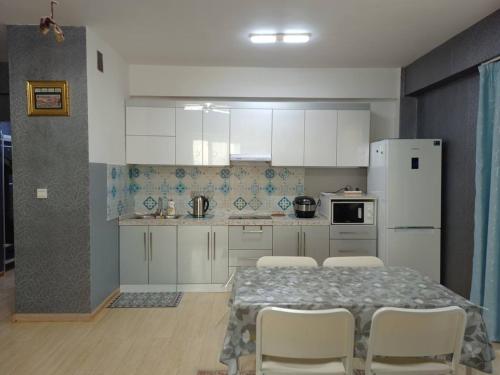 乌兰巴托OUNT-Central location, spacious, cozy and secure的厨房配有桌椅和白色冰箱。