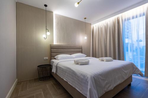 马马亚DelSool Mamaia的一间卧室配有一张大床和两条毛巾