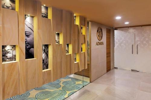 加尔各答Barsana Boutique Hotel - Pure vegetarian的大堂设有走廊,门上设有门,墙上挂有图片