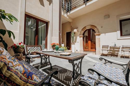 锡拉库扎克雅诺斯住宅酒店的庭院配有木桌和椅子