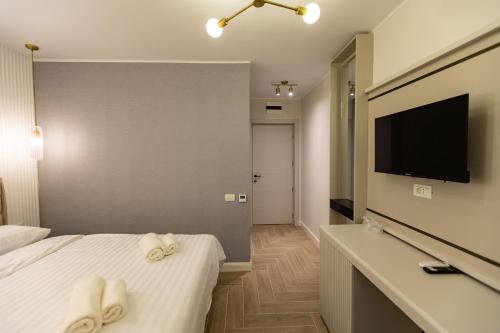 马马亚DelSool Mamaia的酒店客房,在床上配有2条毛巾,配有电视