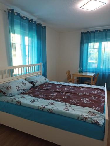 Lahr-DinglingenZimmer "Türkis"的一间卧室配有一张带蓝色窗帘的床和一张桌子