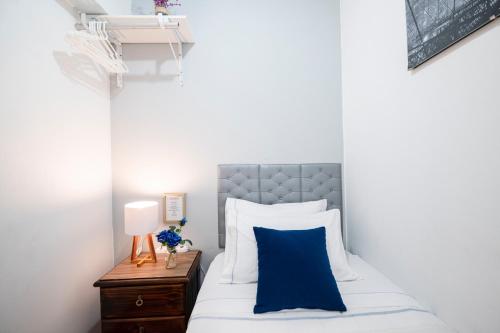 利马Hab Pequeña baño compartido La Paz 4的一间卧室配有一张带蓝色枕头的床和床头柜