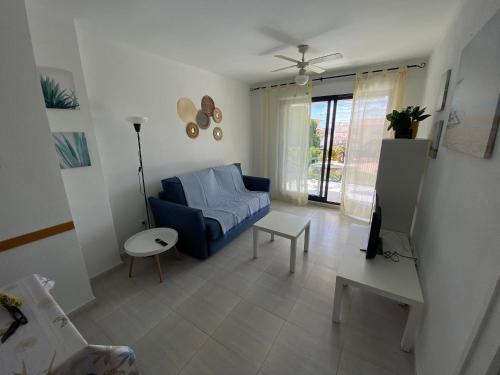 阿尔考斯布里Apartamentos Porta Mediterranea Altamar的客厅配有蓝色的沙发和桌子