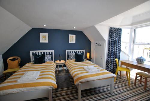 安斯特拉瑟Shore Cottage Anstruther- stylish home by the sea的蓝色墙壁客房的两张床