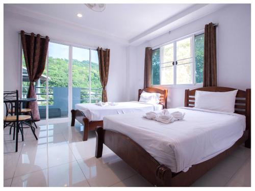 涛岛南哈辛豪斯宾馆的一间卧室设有两张床、一张桌子和窗户。