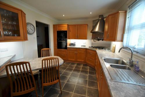 KilrennyOrchard Cottage-spacious cottage in rural setting的厨房配有木制橱柜、水槽和柜台。