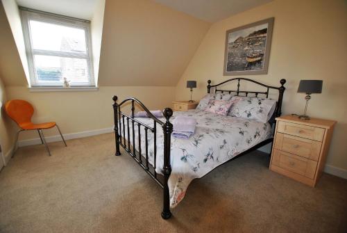 KilrennyOrchard Cottage-spacious cottage in rural setting的卧室配有床、椅子和窗户。