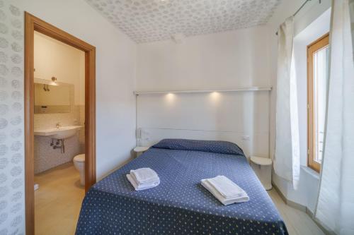 阿祖罗港Affittacamere Vista Mare的一间卧室配有蓝色的床和2条毛巾
