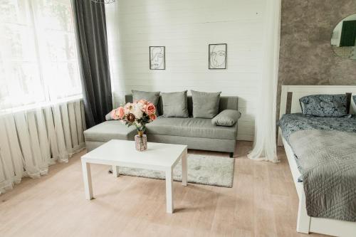 ĶegumsStudio type apartment in Ķegums的客厅配有沙发和鲜花桌