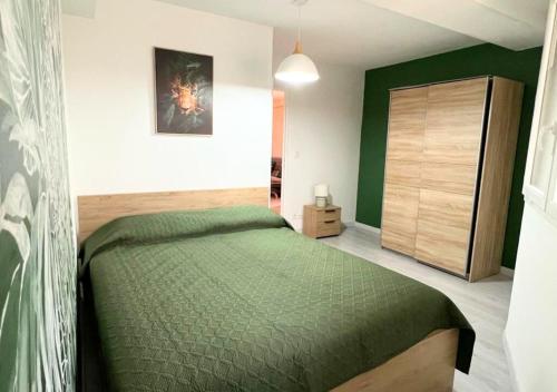普瓦捷Chez Aïda-Centre Ville Poitiers-La Conciergerie.的一间卧室配有一张绿色的床和一个衣柜