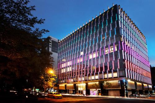 高雄翰品酒店高雄的一座建筑用粉红色和紫色点亮