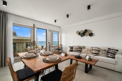 莫拉托斯Milatos Seaside Suites的客厅配有桌椅和沙发