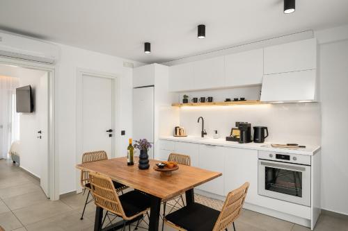 莫拉托斯Milatos Seaside Suites的厨房以及带木桌和椅子的用餐室。