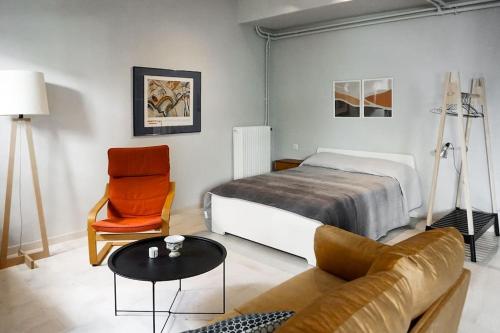 阿尔戈斯Studio 70的一间卧室配有一张床、一张沙发和一把椅子