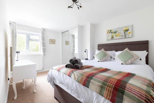 切尔滕纳姆Luxury Cheltenham Home with EV charger - Lechampton Hills的白色的卧室设有一张大床和一个窗户