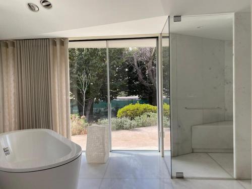 波尔图Boomerang House - Luxury House next to City Park的带浴缸的白色浴室和滑动玻璃门