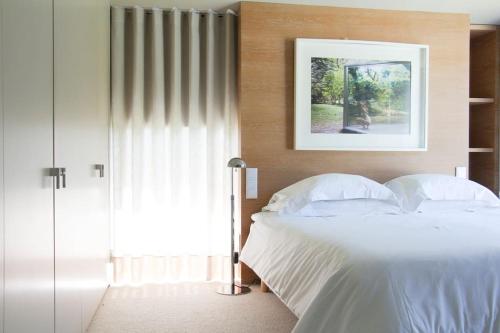 波尔图Boomerang House - Luxury House next to City Park的卧室配有白色的床和镜子