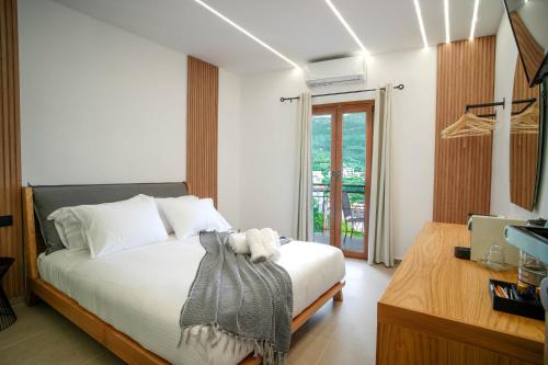 帕尔加Omnia Deluxe Rooms的一间卧室配有一张带白色床单的床和电视。