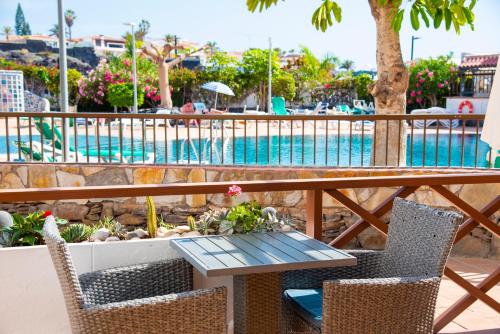 圣地亚哥港Neptuno Pool and beach private access的游泳池旁的桌椅