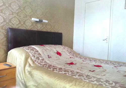 布莱克浦Lynwood Hotel & Spa的一张带棕色床头板的床上,上面有玫瑰花